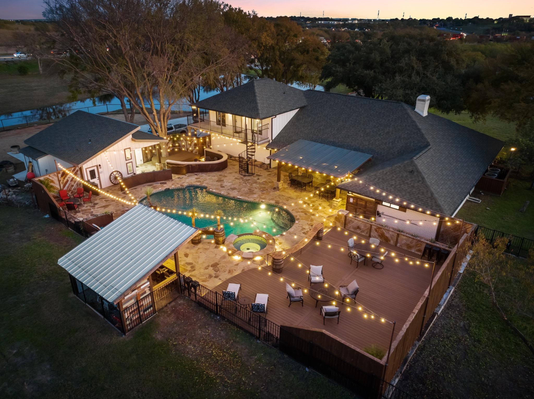 Aerial view of Cowtown Casa, its decks, pool, and surrounding trees