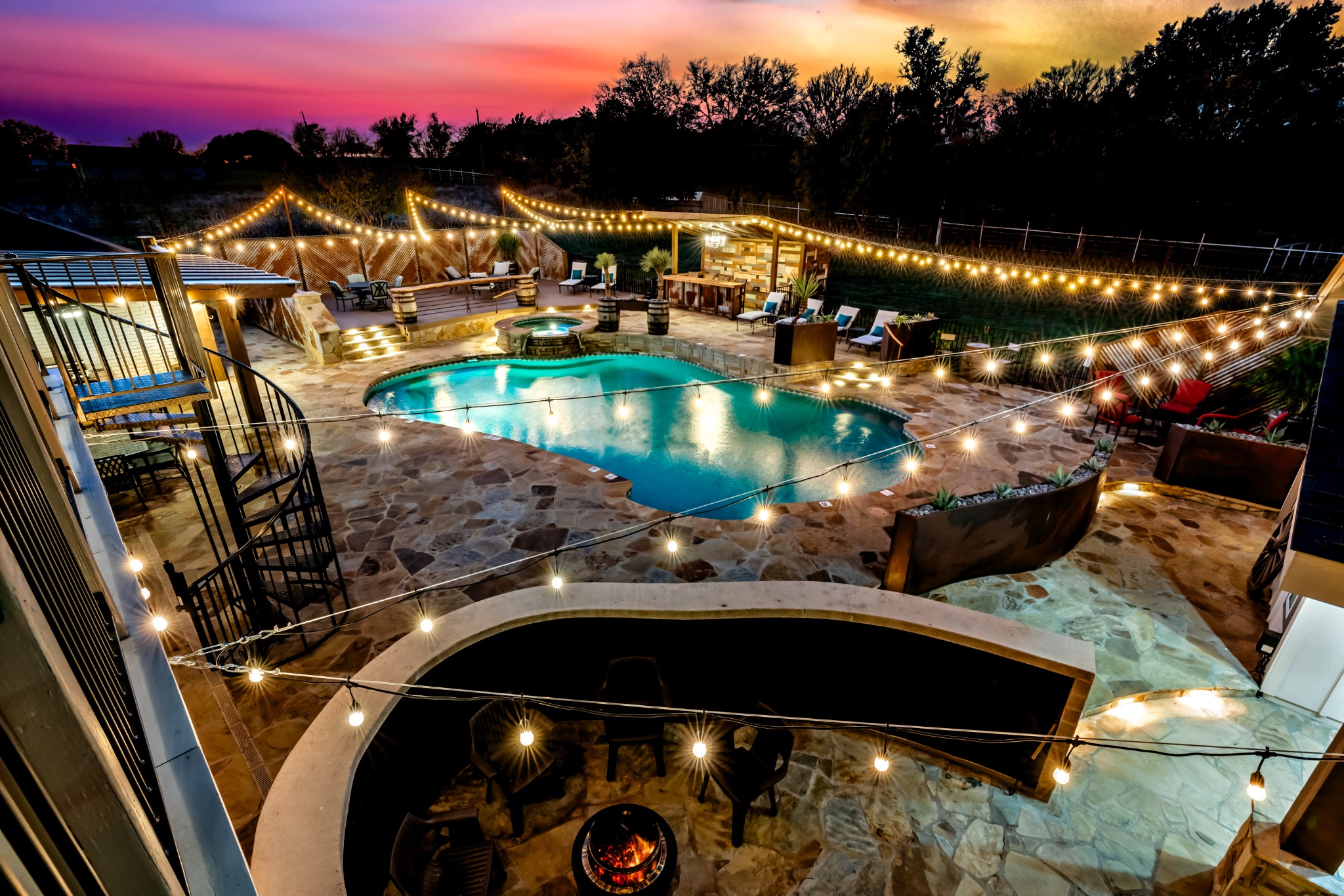The pool and terraces beneath a colorful sunset